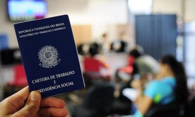 Mão segura uma carteira de trabalho