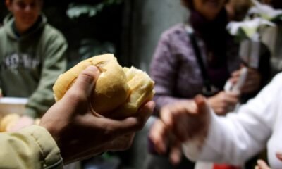 pessoa distribuindo um pedaço de pão